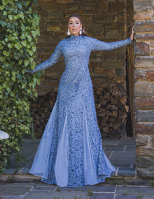  Woman wearing modest fitted blue floral lace gown with long sleeves.