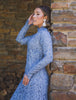 Woman wearing modest fitted blue floral lace gown with long sleeves.