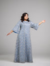 A woman wearing a plus size sky blue modest gown with a silver honeycomb overlay and flare sleeves.